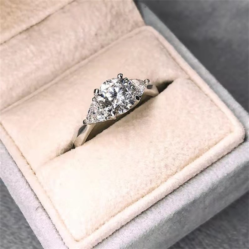 
                  
                    1.0 CT Round Shaped Moissanite Engagement Ring With Three Stone Style
                  
                